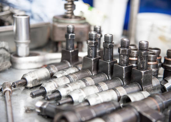 The old diesel injectors lie on the table in the fuel shop. The concept of repair of fuel diesel equipment